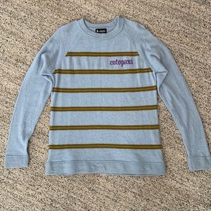 Cotopaxi light blue sweater with stripes.